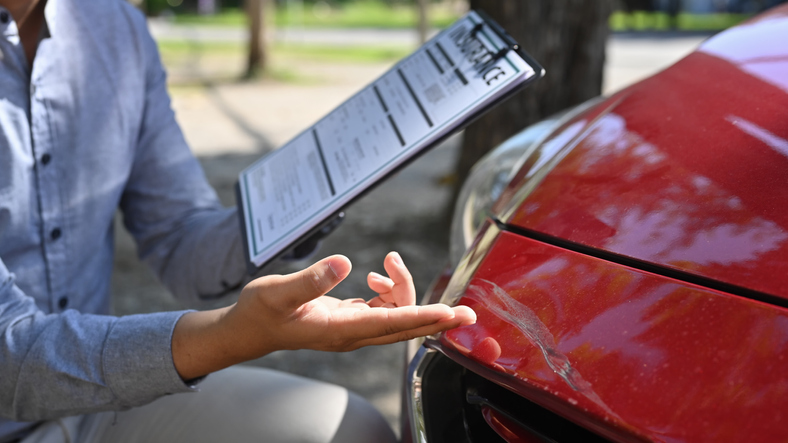 Ajustador de reclamos revisando un carro ante un reclamo de indemnizacion.